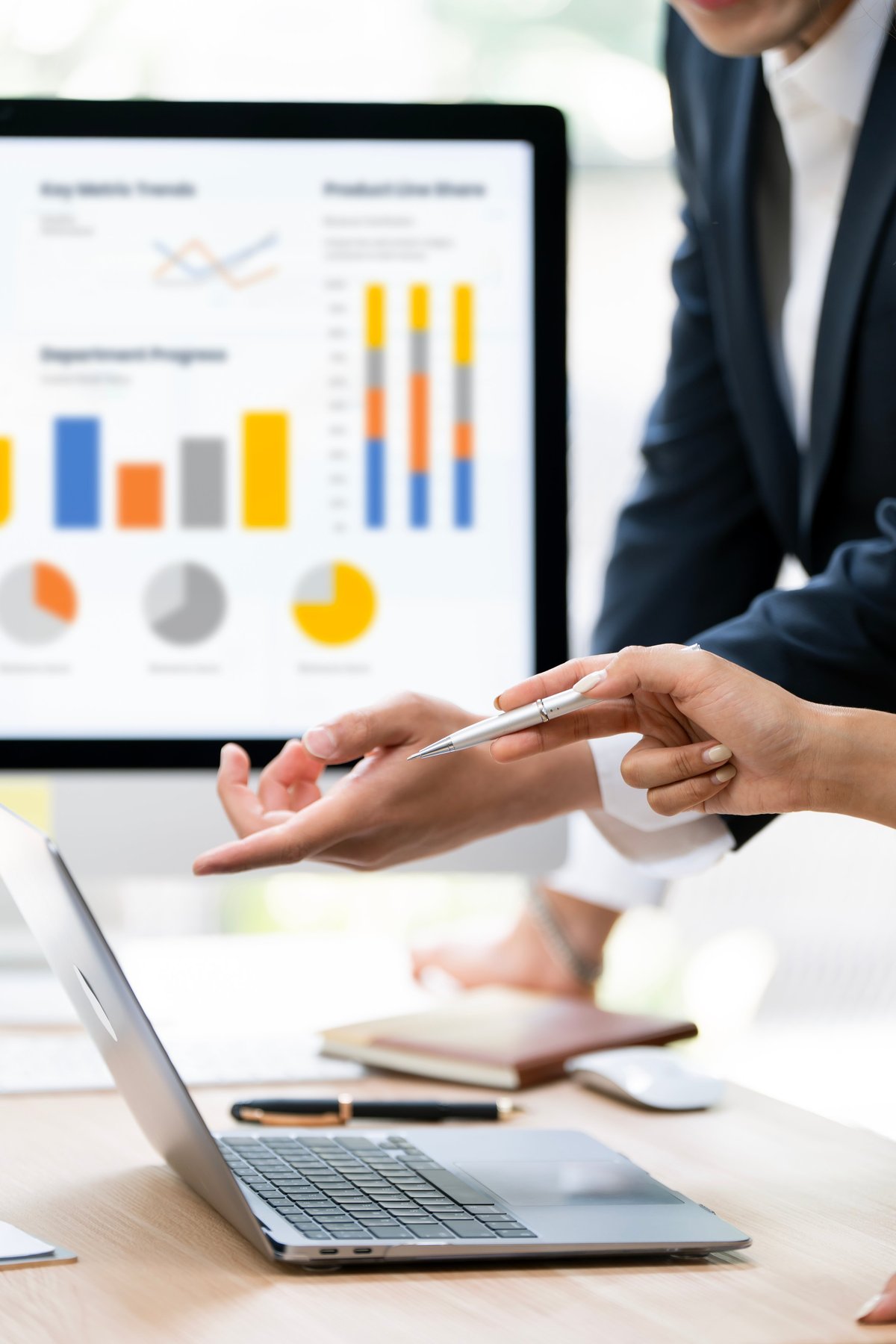 Partners analysing a financial dashboard on a laptop